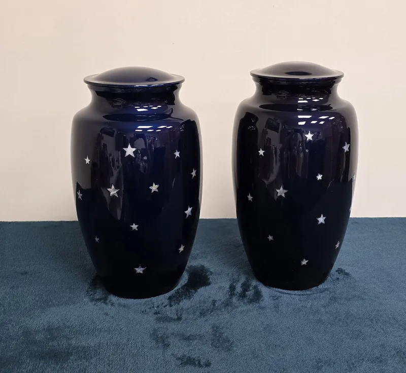 A pair of navy urns with gold and white stars