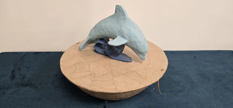 A dolphin on a carved wooden base