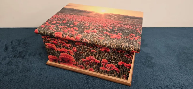 A casket with a field of poppies across the lid