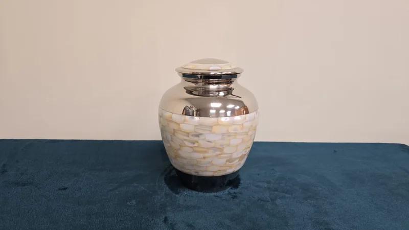 A small pearlised metal keepsake urn
